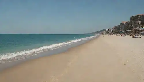 Una playa soleada con agua azul tranquila